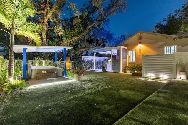 213 N Hesperides St, Tampa, FL 33609 - yard at night featuring a hot tub and a lawn