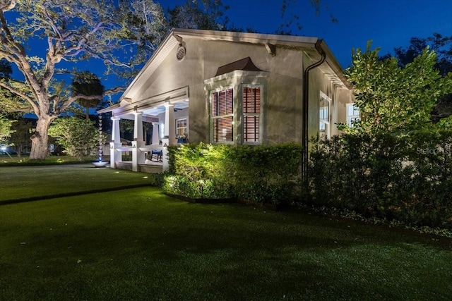 213 N Hesperides St, Tampa, FL 33609 - property exterior at twilight with a yard and stucco siding