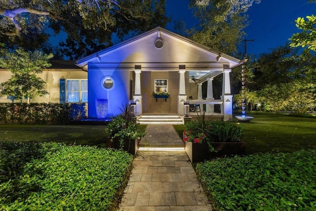 213 N Hesperides St, Tampa, FL 33609 - neoclassical home with a porch, a yard, and stucco siding