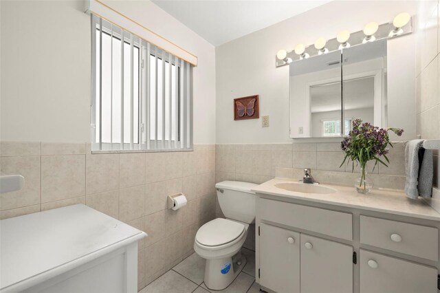 5800 3rd St S, Saint Petersburg, FL 33705 - bathroom with tile walls, vanity, tile patterned floors, and wainscoting