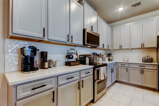 2456 Arbor Wind Dr, Lutz, FL 33558 - kitchen with appliances with stainless steel finishes, light countertops, backsplash, and light tile patterned floors