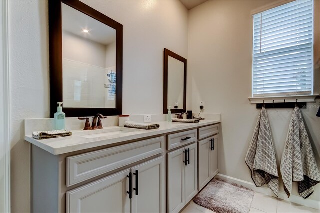 2456 Arbor Wind Dr, Lutz, FL 33558 - bathroom with double vanity, a tile shower, tile patterned flooring, and healthy amount of natural light