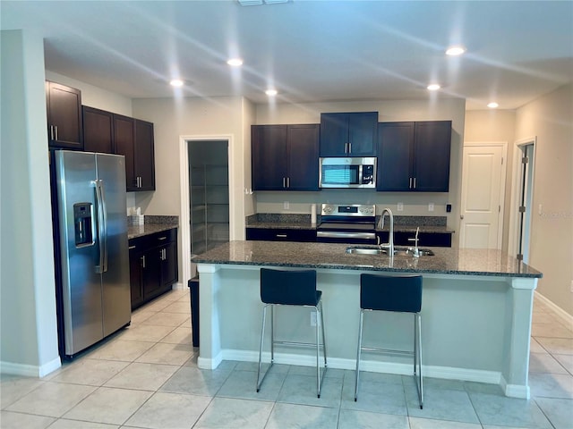 9520 Lemon Drop Loop, Sun City Center, FL 33573 - kitchen with stainless steel appliances, a sink, a kitchen bar, recessed lighting, and light tile patterned flooring