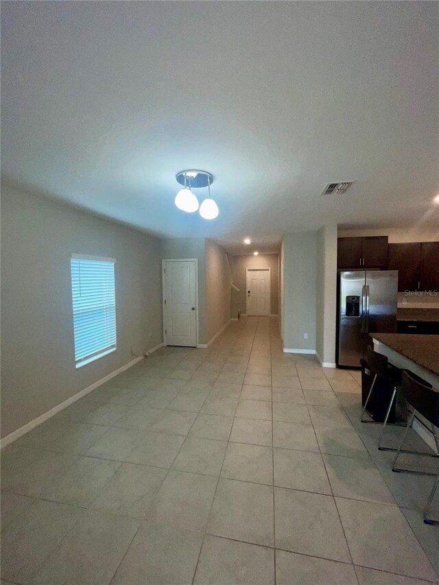 9520 Lemon Drop Loop, Sun City Center, FL 33573 - unfurnished living room featuring baseboards and light tile patterned flooring