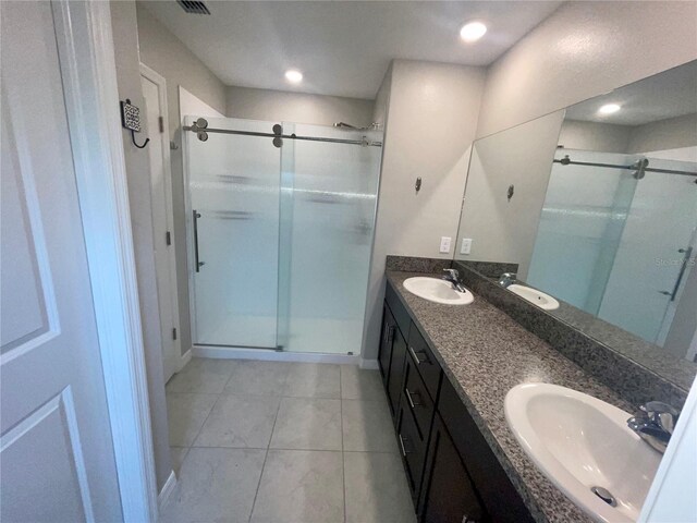 9520 Lemon Drop Loop, Sun City Center, FL 33573 - bathroom featuring a stall shower, double vanity, tile patterned floors, and baseboards