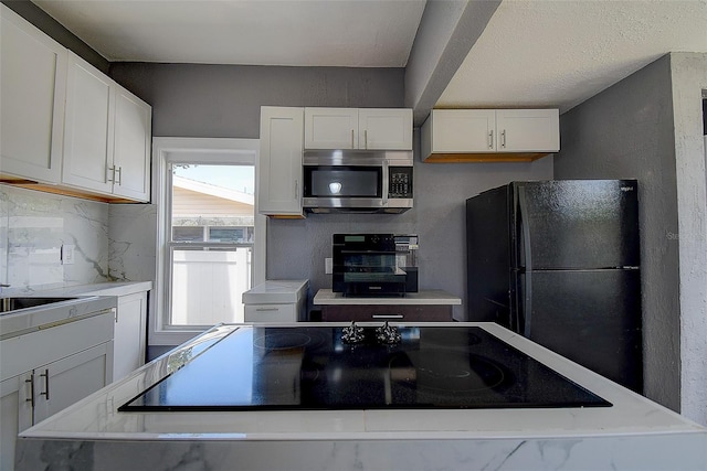 2627 17th Ave N, Saint Petersburg, FL 33713 - kitchen featuring black appliances, white cabinets, tasteful backsplash, and light countertops