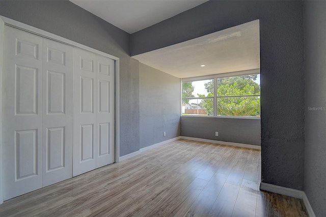2627 17th Ave N, Saint Petersburg, FL 33713 - unfurnished bedroom with wood finished floors, baseboards, a closet, and a textured wall