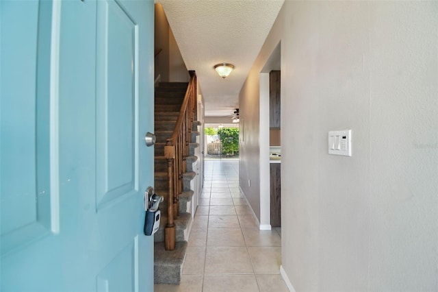 2131 Ridge Rd S Unit 3, Largo, FL 33778 - entryway with light tile patterned floors, a textured ceiling, baseboards, stairs, and a ceiling fan