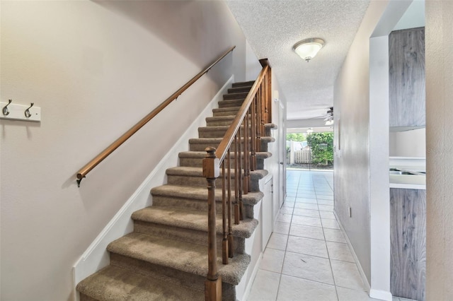 2131 Ridge Rd S Unit 3, Largo, FL 33778 - stairs with a textured ceiling, a ceiling fan, tile patterned floors, and baseboards