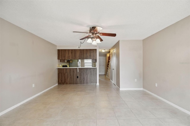 2131 Ridge Rd S Unit 3, Largo, FL 33778 - unfurnished living room with ceiling fan, light tile patterned flooring, a textured ceiling, and baseboards