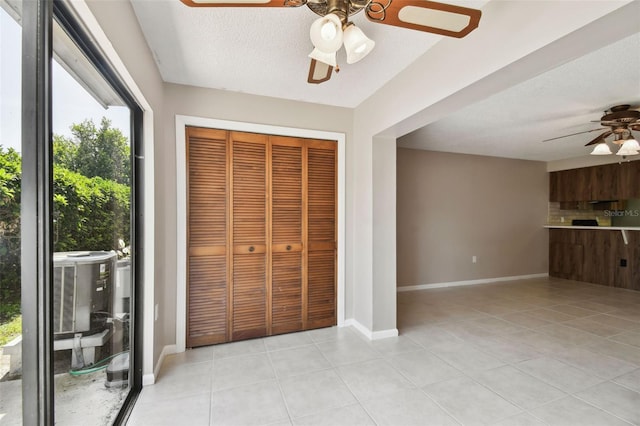2131 Ridge Rd S Unit 3, Largo, FL 33778 - unfurnished bedroom featuring light tile patterned flooring, a closet, ceiling fan, a textured ceiling, and baseboards