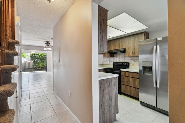 2131 Ridge Rd S Unit 3, Largo, FL 33778 - kitchen featuring stainless steel refrigerator with ice dispenser, light tile patterned flooring, under cabinet range hood, black / electric stove, and decorative backsplash
