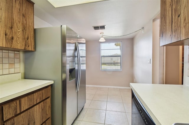 2131 Ridge Rd S Unit 3, Largo, FL 33778 - kitchen featuring stainless steel fridge, light countertops, brown cabinets, decorative backsplash, and baseboards