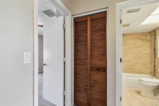 2131 Ridge Rd S Unit 3, Largo, FL 33778 - full bathroom with toilet, washtub / shower combination, a closet, and a textured ceiling