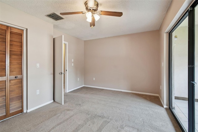 2131 Ridge Rd S Unit 3, Largo, FL 33778 - unfurnished bedroom with carpet flooring, baseboards, a textured ceiling, a ceiling fan, and a closet