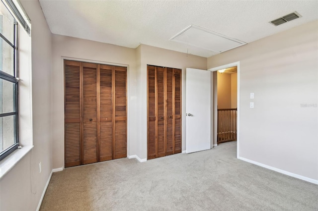 2131 Ridge Rd S Unit 3, Largo, FL 33778 - unfurnished bedroom with attic access, carpet flooring, multiple windows, baseboards, and a textured ceiling