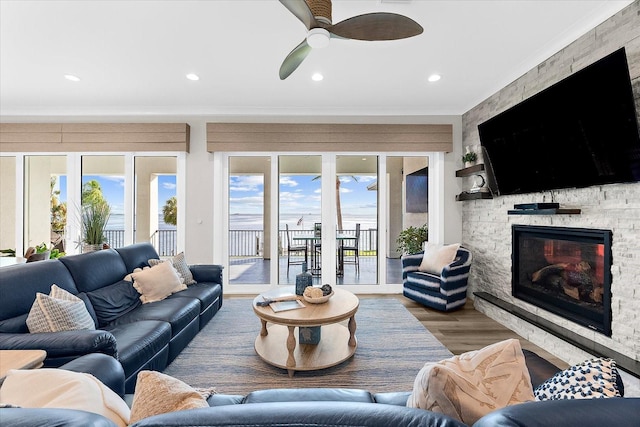 110 Carlyle Dr, Palm Harbor, FL 34683 - living room featuring crown molding, a fireplace, healthy amount of natural light, wood finished floors, and a ceiling fan