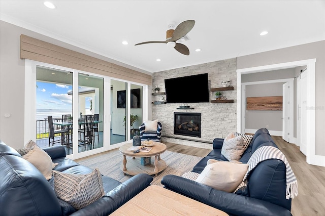 110 Carlyle Dr, Palm Harbor, FL 34683 - living room with ceiling fan, wood finished floors, a stone fireplace, and recessed lighting