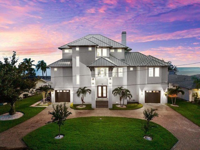 110 Carlyle Dr, Palm Harbor, FL 34683 - contemporary house featuring decorative driveway, a standing seam roof, an attached garage, a balcony, and a metal roof