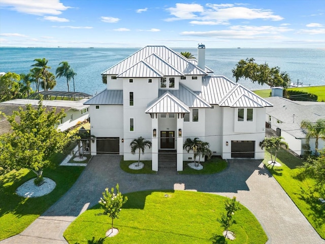 110 Carlyle Dr, Palm Harbor, FL 34683 - view of front of home featuring an attached garage, decorative driveway, stucco siding, and a standing seam roof