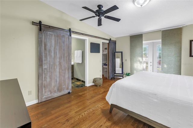 7461 Pescador Pl, Seminole, FL 33772 - bedroom with a barn door, lofted ceiling, wood finished floors, baseboards, and access to exterior
