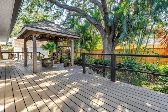 7461 Pescador Pl, Seminole, FL 33772 - deck featuring a fenced backyard, a gazebo, and a fire pit