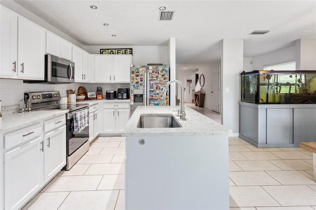 8415 Edgewater Place Blvd, Tampa, FL 33615 - kitchen with stainless steel appliances, a sink, light tile patterned flooring, an island with sink, and backsplash