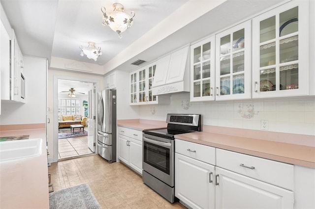2110 Reaney Rd, Lakeland, FL 33803 - kitchen featuring appliances with stainless steel finishes, white cabinets, and decorative backsplash