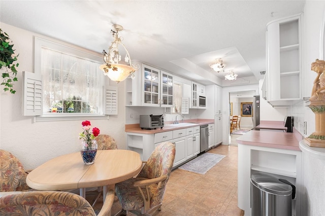 2110 Reaney Rd, Lakeland, FL 33803 - kitchen with dishwasher, a chandelier, a sink, white cabinetry, and open shelves