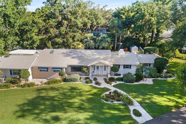 2110 Reaney Rd, Lakeland, FL 33803 - view of front of property with a front lawn, covered porch, a chimney, and a shingled roof
