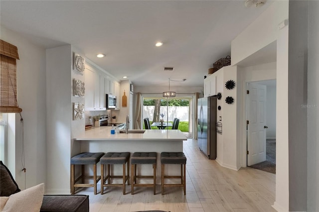 11728 Crest Creek Dr, Riverview, FL 33569 - kitchen featuring stainless steel appliances, a sink, white cabinets, a peninsula, and light countertops