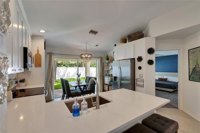 11728 Crest Creek Dr, Riverview, FL 33569 - kitchen with stainless steel appliances, a peninsula, white cabinets, a breakfast bar, and light countertops