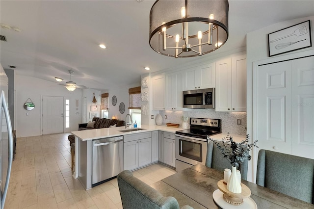 11728 Crest Creek Dr, Riverview, FL 33569 - kitchen with appliances with stainless steel finishes, a sink, backsplash, a peninsula, and open floor plan