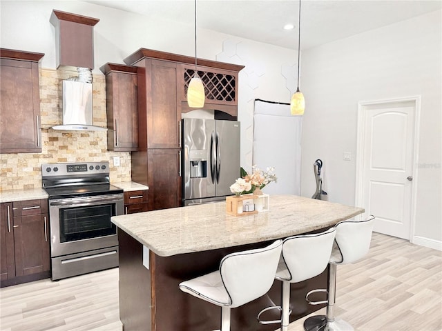 2137 W Saint Louis St, Tampa, FL 33607 - kitchen with stainless steel appliances, wall chimney range hood, light wood-style floors, and decorative backsplash