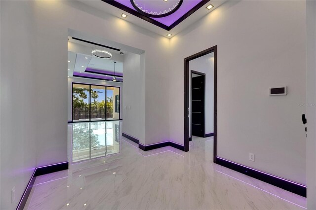 6532 Simone Shores Cir, Apollo Beach, FL 33572 - empty room featuring a tray ceiling, baseboards, and marble tiled floors