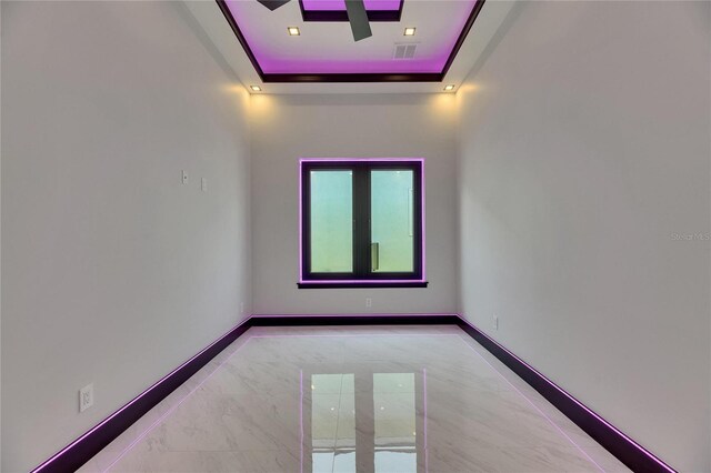 6532 Simone Shores Cir, Apollo Beach, FL 33572 - unfurnished room featuring a raised ceiling, baseboards, and marble finish flooring