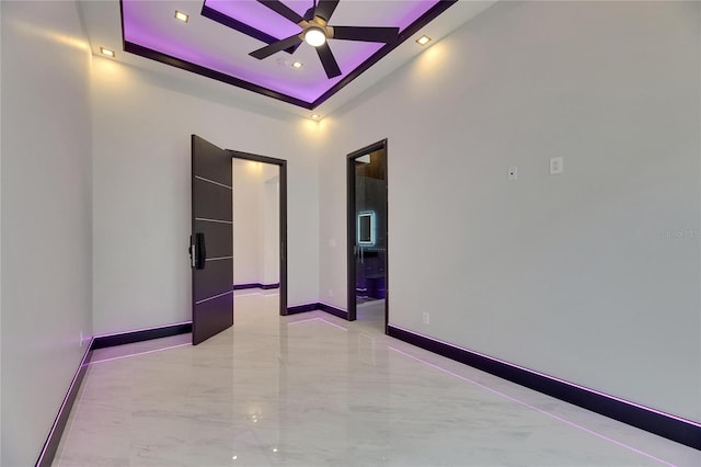 6532 Simone Shores Cir, Apollo Beach, FL 33572 - unfurnished room with a ceiling fan, a raised ceiling, light marble finish flooring, baseboards, and recessed lighting
