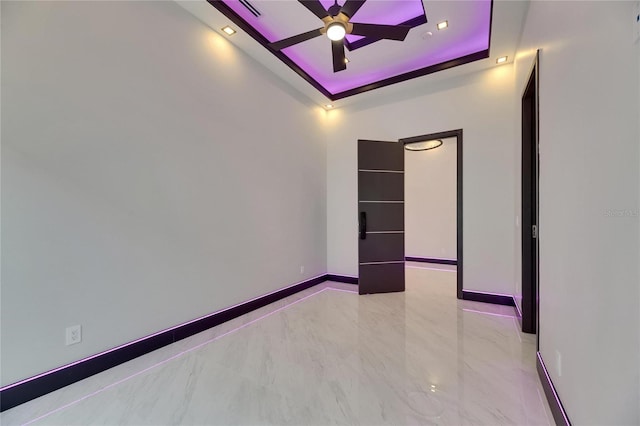 6532 Simone Shores Cir, Apollo Beach, FL 33572 - spare room with ceiling fan, a tray ceiling, baseboards, and marble finish floors