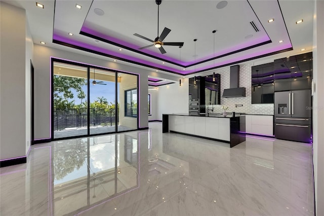 6532 Simone Shores Cir, Apollo Beach, FL 33572 - kitchen featuring wall chimney exhaust hood, modern cabinets, a tray ceiling, and a ceiling fan