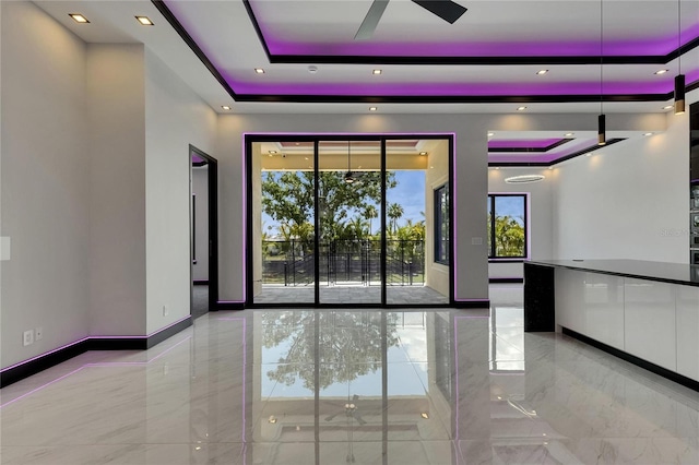 6532 Simone Shores Cir, Apollo Beach, FL 33572 - unfurnished room with a tray ceiling, marble tiled flooring, a ceiling fan, and baseboards