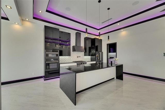 6532 Simone Shores Cir, Apollo Beach, FL 33572 - kitchen featuring wall chimney exhaust hood, light marble finish flooring, backsplash, modern cabinets, and a tray ceiling