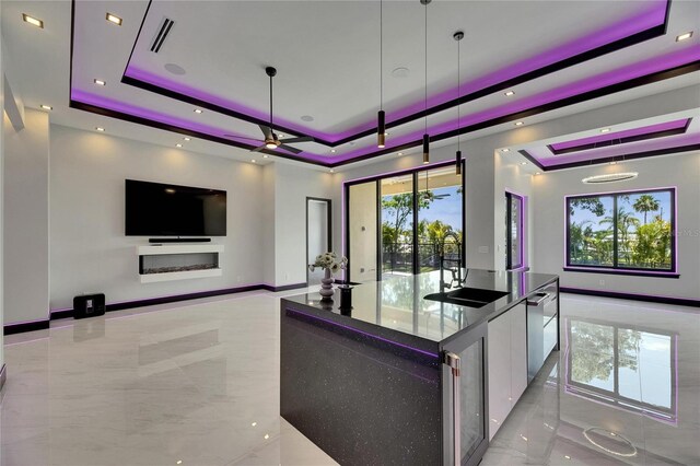 6532 Simone Shores Cir, Apollo Beach, FL 33572 - kitchen with a raised ceiling, a sink, and light marble finish flooring