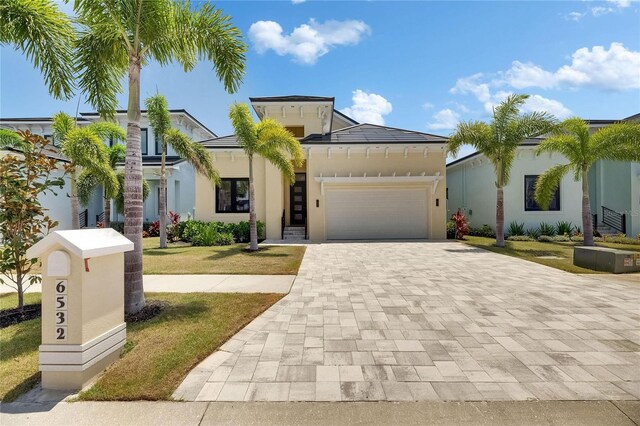 6532 Simone Shores Cir, Apollo Beach, FL 33572 - view of front of home featuring decorative driveway, an attached garage, a front lawn, and stucco siding
