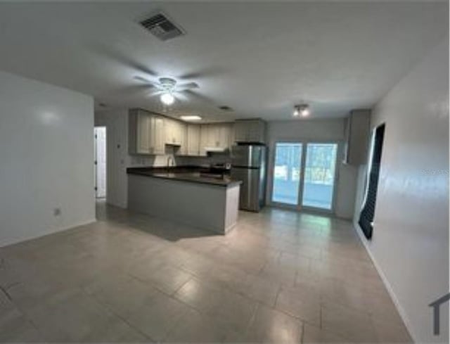 16599 Davis Rd Unit 16599, Fort Myers, FL 33908 - kitchen featuring freestanding refrigerator, dark countertops, open floor plan, and a ceiling fan