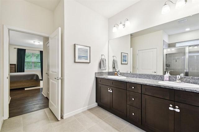 32825 Sand Creek Dr, Wesley Chapel, FL 33543 - ensuite bathroom with double vanity, a shower stall, tile patterned flooring, and baseboards