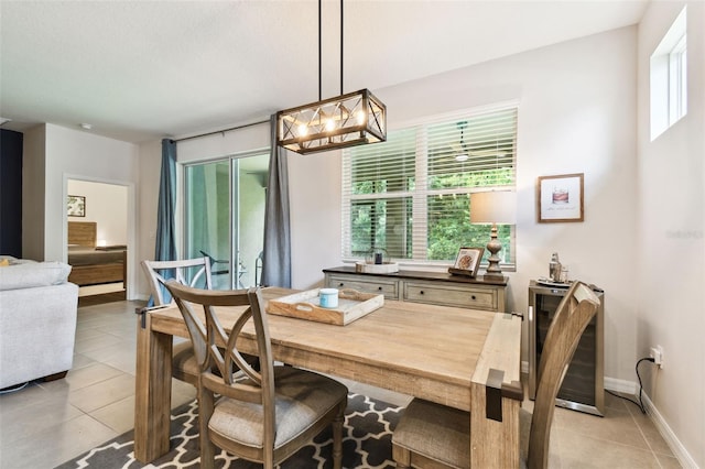 32825 Sand Creek Dr, Wesley Chapel, FL 33543 - dining room with beverage cooler, light tile patterned floors, a chandelier, and baseboards