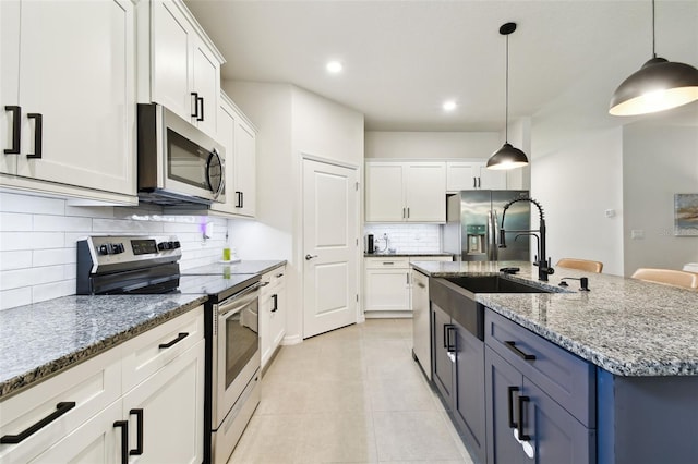 32825 Sand Creek Dr, Wesley Chapel, FL 33543 - kitchen featuring appliances with stainless steel finishes, a sink, tasteful backsplash, light tile patterned floors, and white cabinets