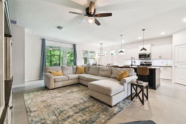 32825 Sand Creek Dr, Wesley Chapel, FL 33543 - living room featuring light tile patterned floors, ceiling fan, recessed lighting, and baseboards