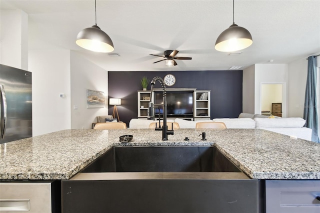 32825 Sand Creek Dr, Wesley Chapel, FL 33543 - kitchen with open floor plan, a sink, and light stone countertops