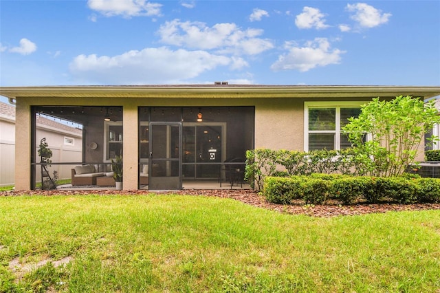 32825 Sand Creek Dr, Wesley Chapel, FL 33543 - back of property featuring a lawn, a sunroom, and stucco siding